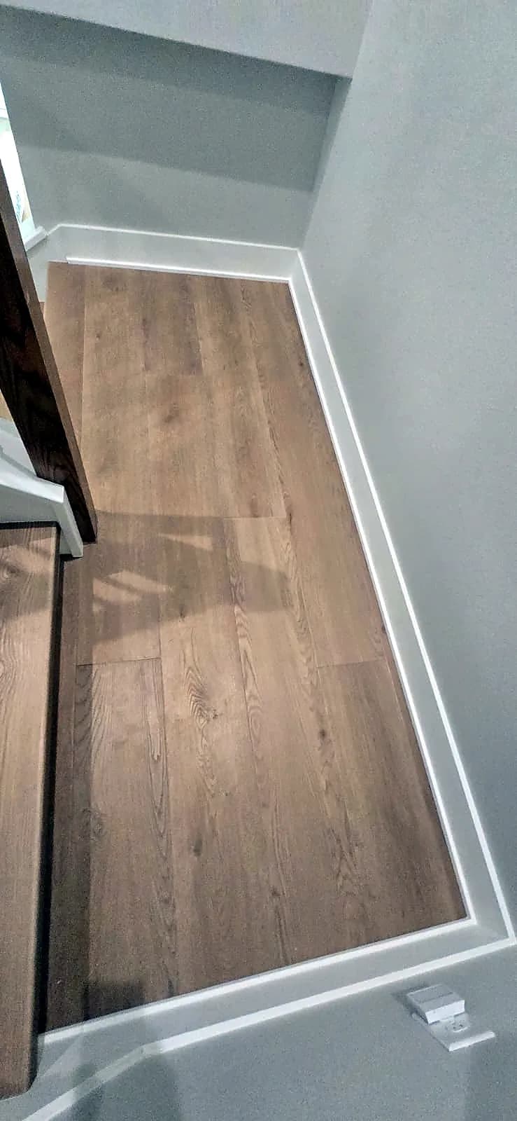 Oak-look plank flooring on an upstairs landing with white baseboards in a Central Florida home