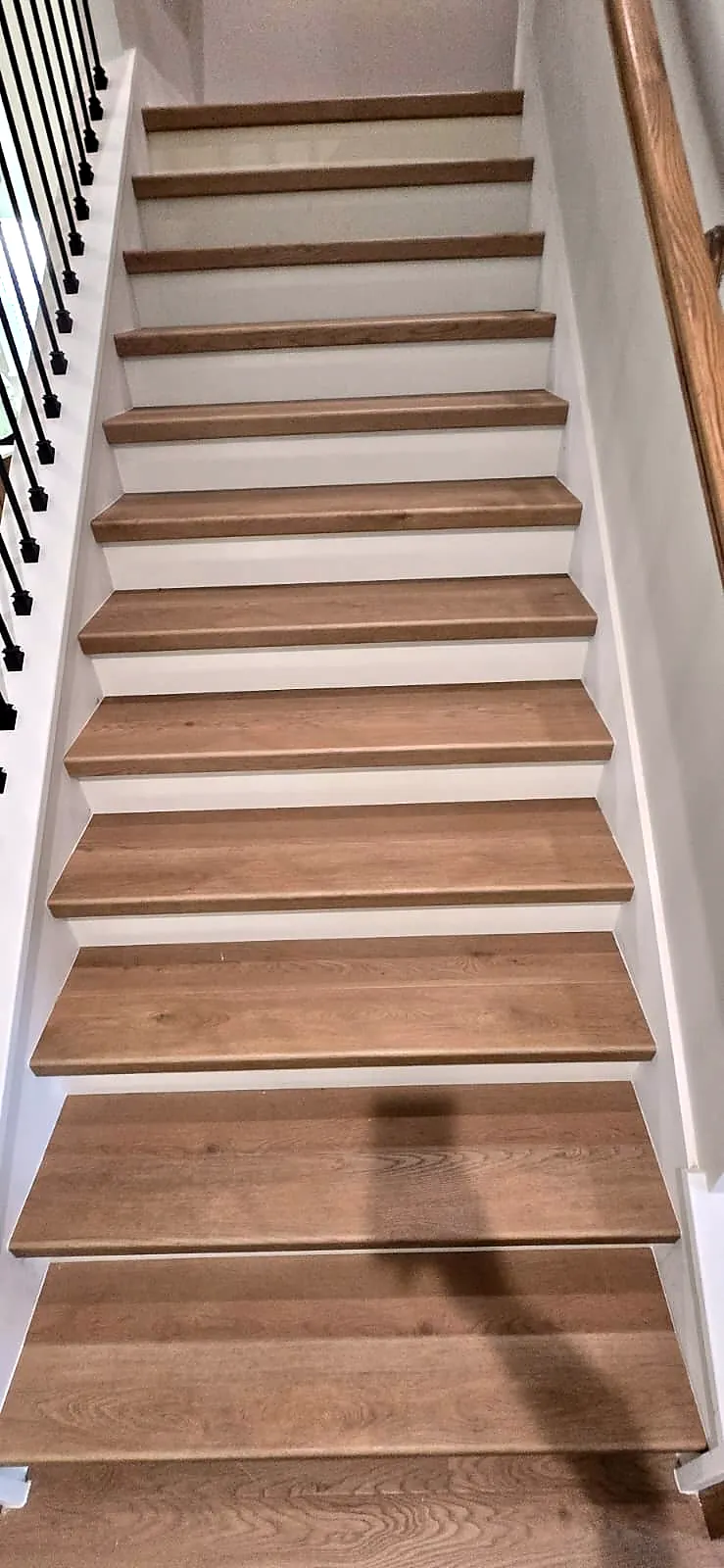 Staircase with oak-look stair treads installed by our flooring team