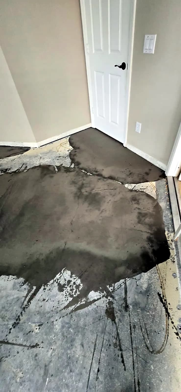 Self-leveling compound being applied to a concrete subfloor ahead of laminate flooring installation
