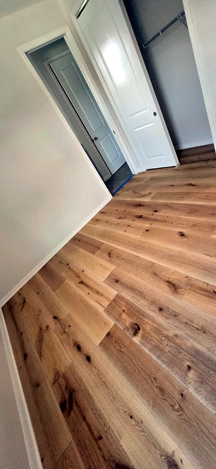 Wide-plank oak-look plank flooring in a bedroom